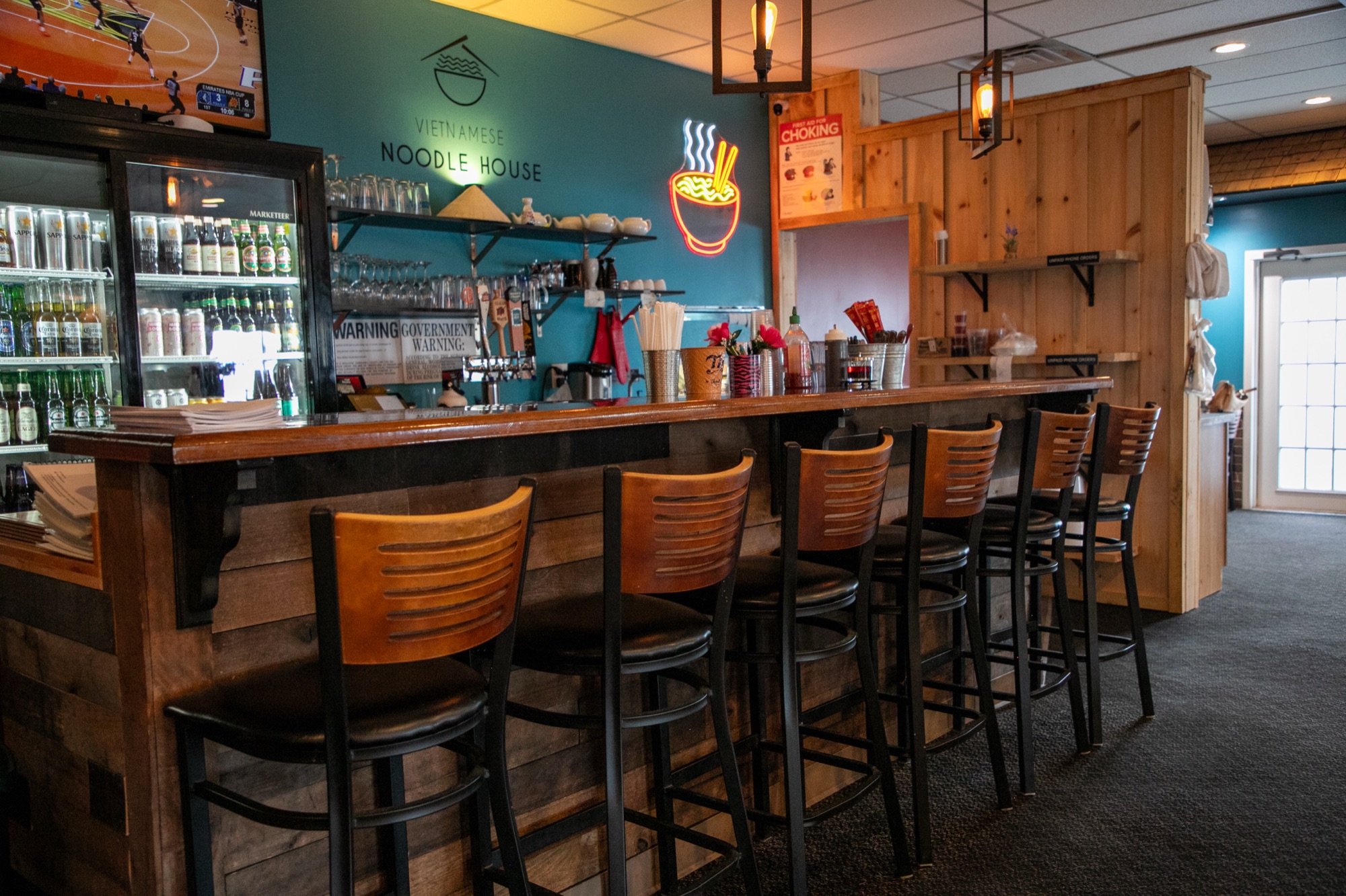 Bar seating with neon noodle bowl sign